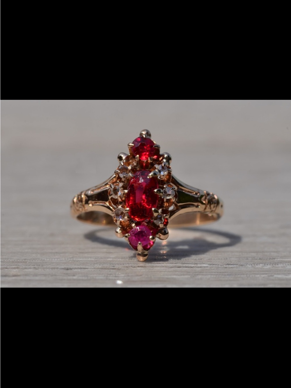 Gold Ring with Vibrant Red Gemstones and Sparkling Accents
